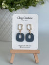 Plu polymer clay earrings with a crystal stud on a 'Clay Couture' branded card with a wooden standSlate Blue