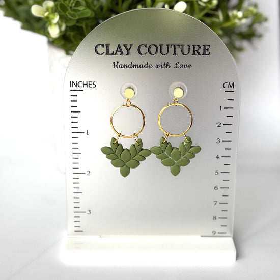 Pair of polymer clay earrings in Olive Grove on Clay Couture branded size stand