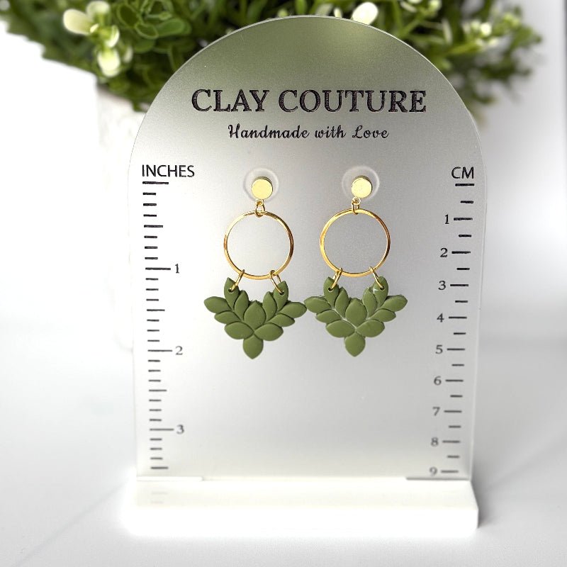 Pair of polymer clay earrings in Olive Grove on Clay Couture branded size stand