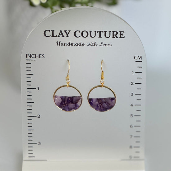 Amethyst and gold hoop earrings on a Clay Couture branded size stand