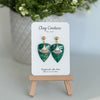 Emerald Green dagger shaped polymer clay  earrings  with a resin finish and gold accents on a Clay Couture branded card.
