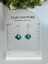 Emrald Green Earrings with gold chain and bow on a size stand showing drop length